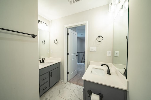 full bathroom with marble finish floor, two vanities, a sink, and visible vents