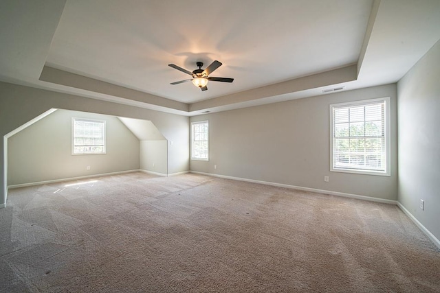 additional living space featuring baseboards, visible vents, a wealth of natural light, and light colored carpet