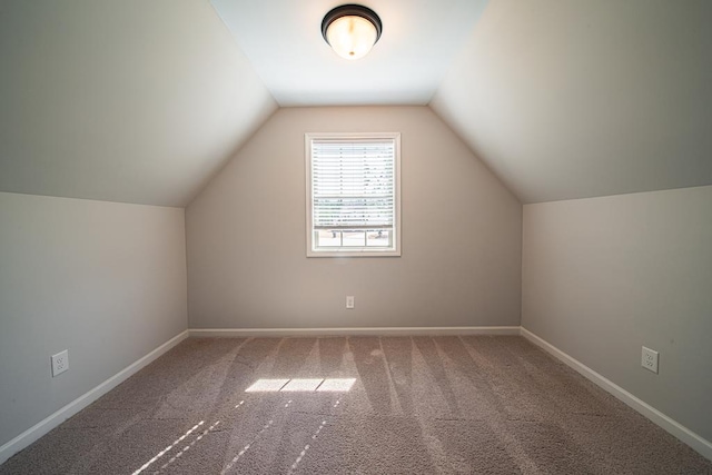 additional living space with carpet, vaulted ceiling, and baseboards