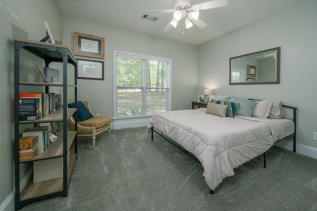 carpeted bedroom featuring ceiling fan, a textured ceiling, baseboards, and visible vents