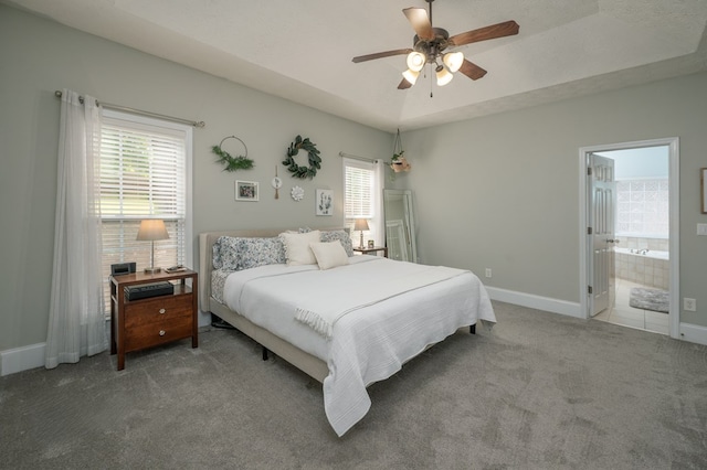 bedroom with ensuite bath, carpet, baseboards, and a ceiling fan