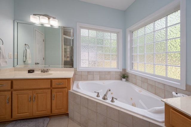 bathroom featuring vanity, a jetted tub, a shower stall, and tile patterned flooring