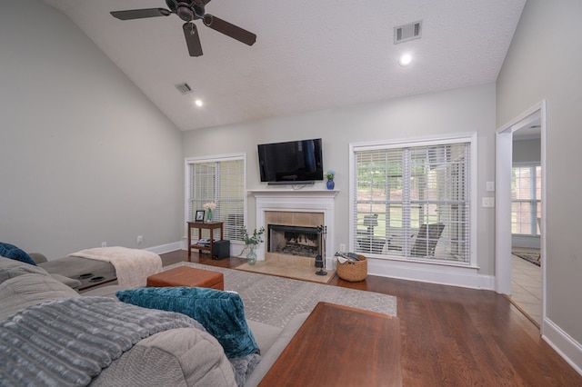 living area with ceiling fan, baseboards, visible vents, and a tile fireplace