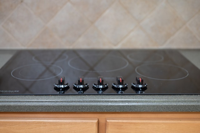 interior details featuring black electric cooktop and dark countertops