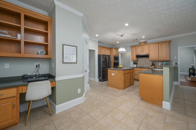 kitchen featuring built in desk, a center island, dark countertops, black appliances, and backsplash