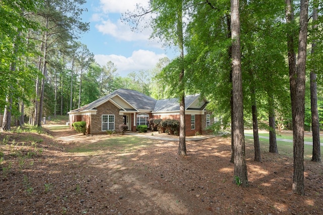 view of front of property featuring brick siding and driveway