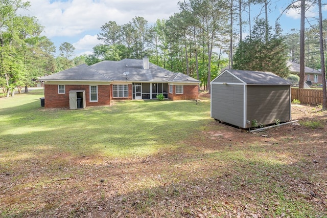 rear view of house with a storage shed, an outdoor structure, a chimney, and a yard