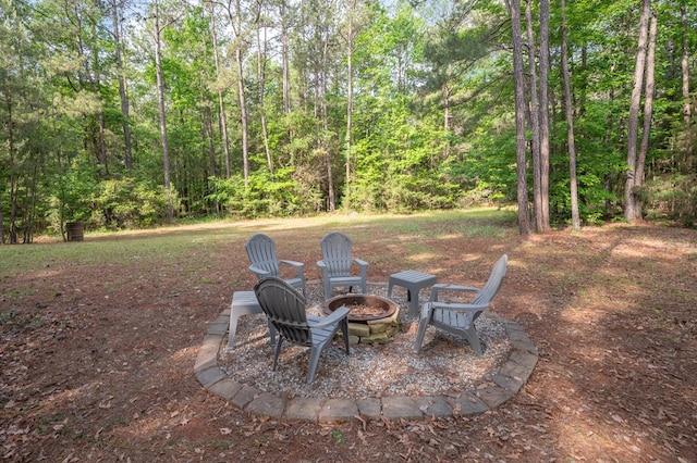 view of yard with a forest view and a fire pit