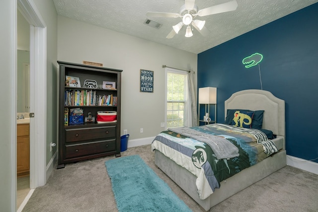 bedroom featuring a textured ceiling, carpet, visible vents, ceiling fan, and baseboards