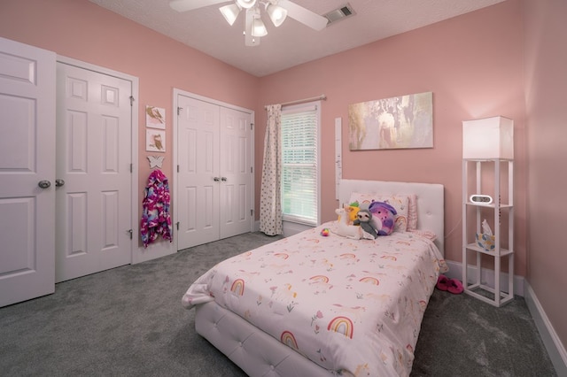 bedroom featuring ceiling fan, visible vents, multiple closets, and carpet floors