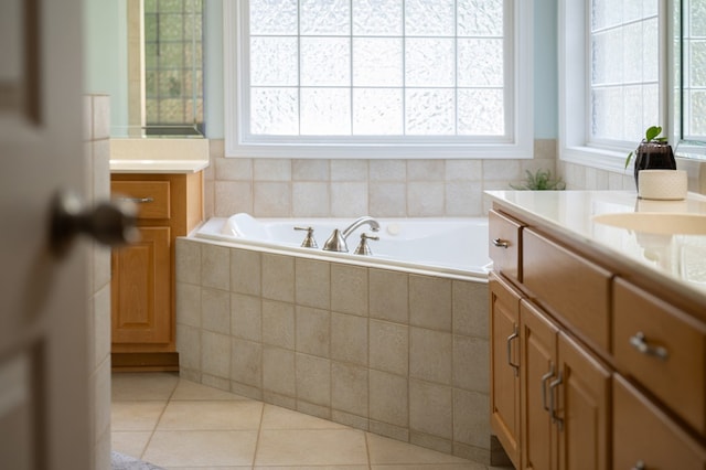 bathroom with a wealth of natural light, vanity, and a bath