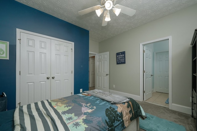 bedroom featuring a closet, a textured ceiling, carpet, baseboards, and ceiling fan