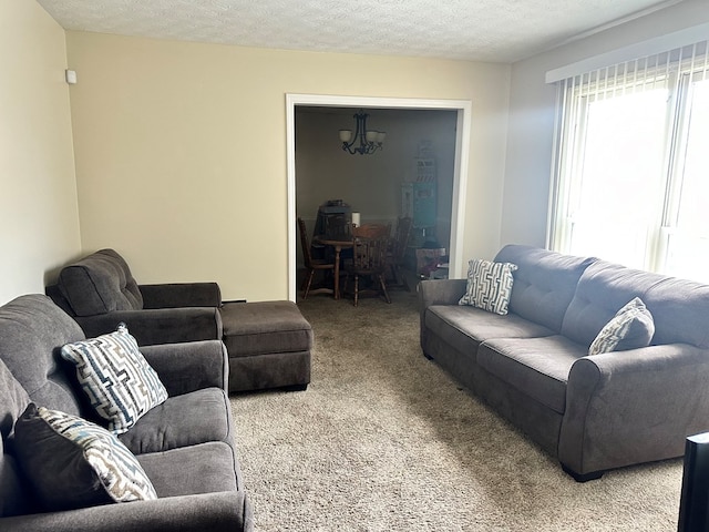 living room with carpet floors, a textured ceiling, and a chandelier