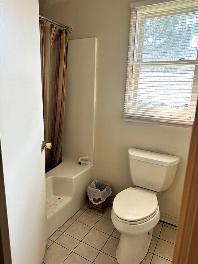 bathroom featuring a shower with curtain, tile patterned flooring, and toilet