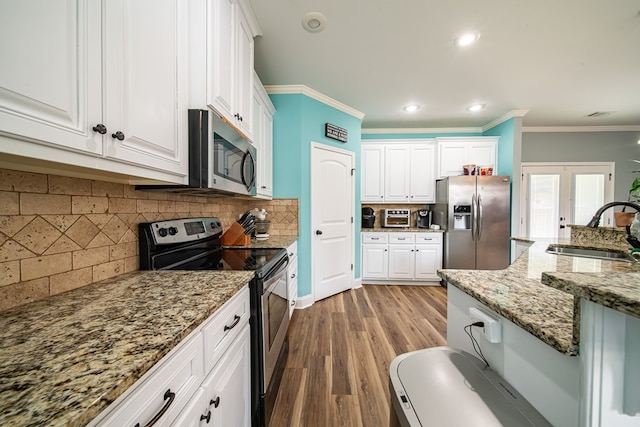 9597 Yarbrough Rd, Midland, GA 31820 - kitchen featuring stainless steel appliances, a sink, white cabinetry, ornamental molding, and light stone countertops
