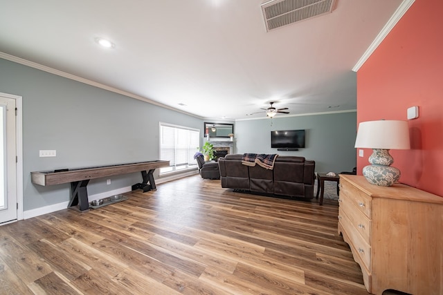 9597 Yarbrough Rd, Midland, GA 31820 - living area featuring ornamental molding, a ceiling fan, wood finished floors, a stone fireplace, and baseboards