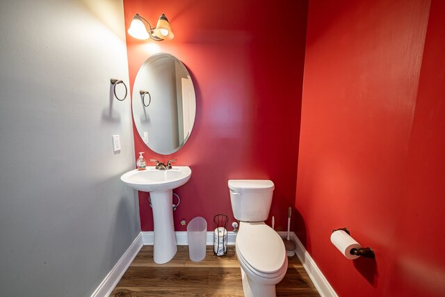 9597 Yarbrough Rd, Midland, GA 31820 - bathroom with wood finished floors, toilet, baseboards, and a sink