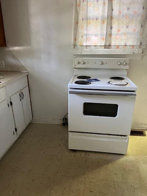 kitchen with white cabinets, baseboards, visible vents, and white range with electric cooktop