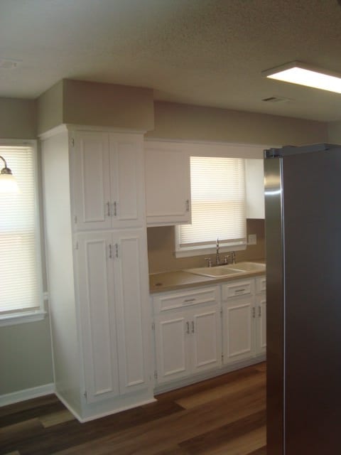 4118 Terrace Pointe Dr, Columbus, GA 31909 - kitchen featuring freestanding refrigerator, white cabinetry, dark wood-type flooring, light countertops, and a textured ceiling
