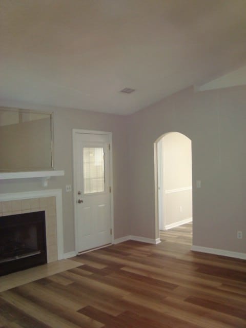 4118 Terrace Pointe Dr, Columbus, GA 31909 - unfurnished living room with arched walkways, wood finished floors, and a fireplace