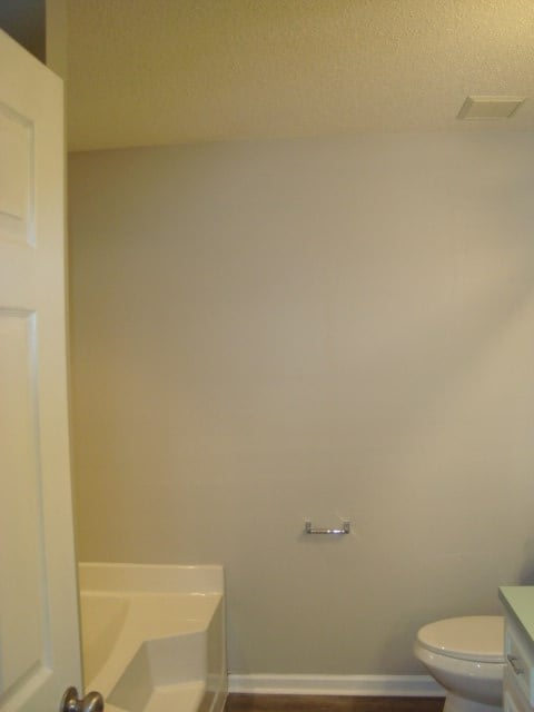 4118 Terrace Pointe Dr, Columbus, GA 31909 - bathroom featuring a textured ceiling, a garden tub, vanity, and wood finished floors
