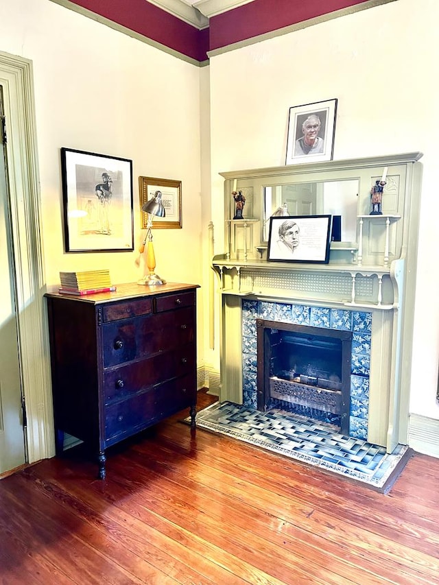 sitting room with hardwood / wood-style floors and a tiled fireplace