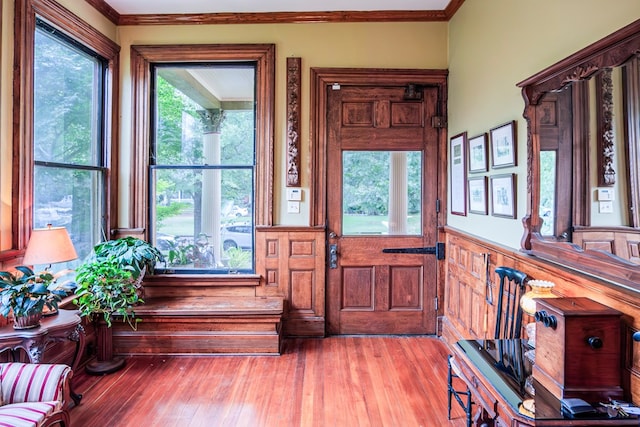 entryway with light hardwood / wood-style floors and ornamental molding