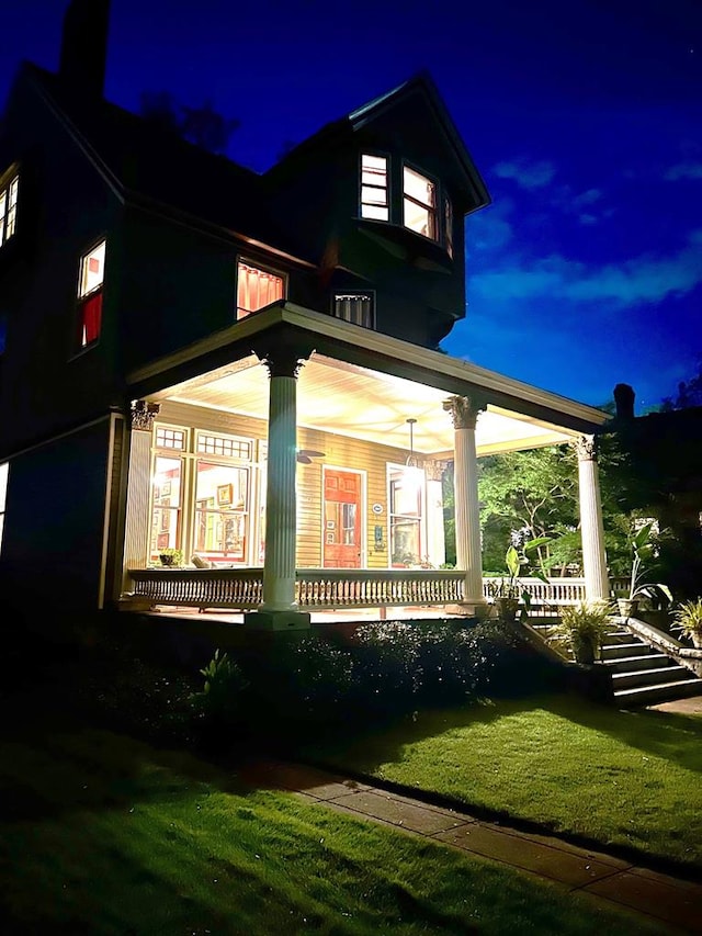 property exterior at night with covered porch