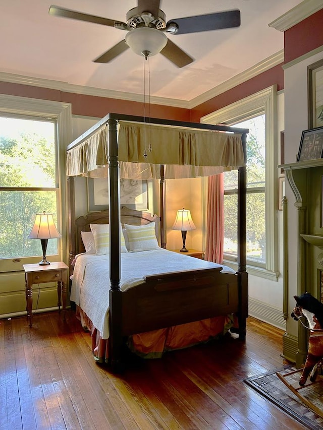 bedroom with multiple windows, ceiling fan, hardwood / wood-style floors, and crown molding