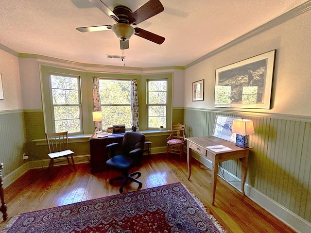 office featuring ceiling fan, hardwood / wood-style floors, wooden walls, and ornamental molding