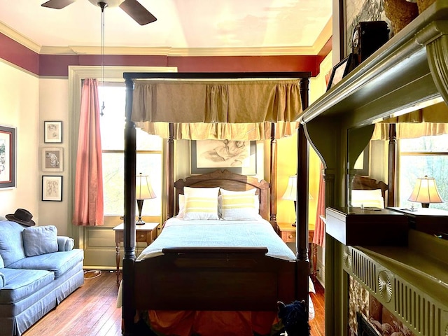 bedroom featuring ceiling fan, ornamental molding, and hardwood / wood-style flooring