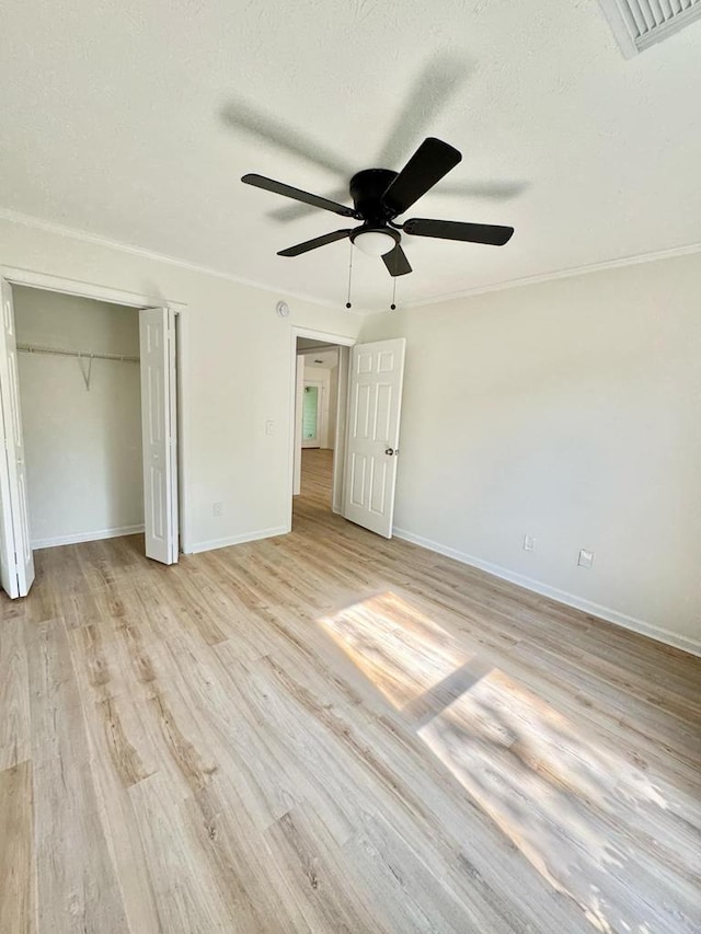 unfurnished bedroom with baseboards, a ceiling fan, light wood finished floors, and visible vents