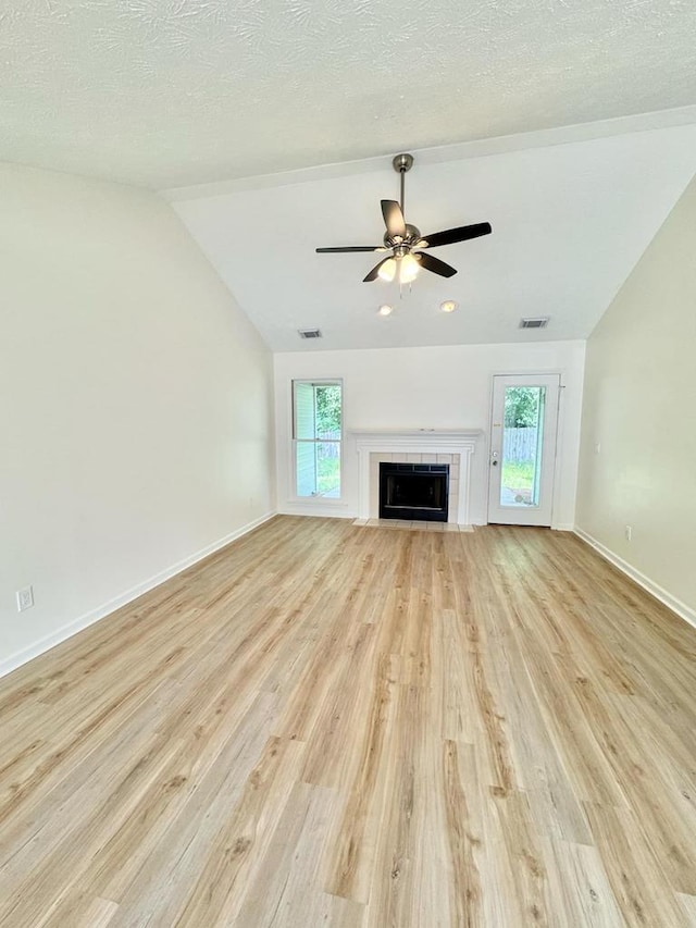 unfurnished living room with visible vents, ceiling fan, vaulted ceiling, and light wood-type flooring