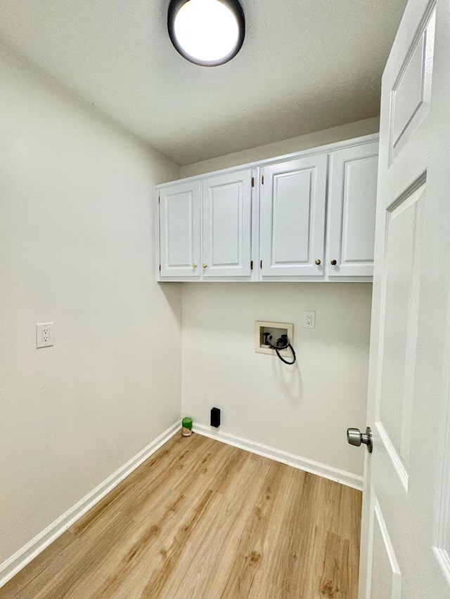 laundry room featuring baseboards, light wood-style flooring, cabinet space, and washer hookup