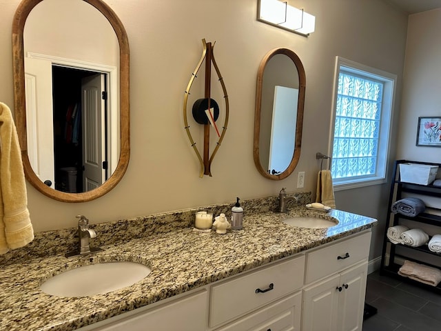 bathroom featuring double vanity, tile patterned floors, and a sink
