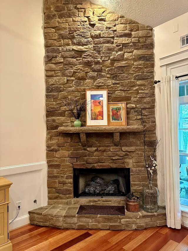 room details featuring visible vents, wood finished floors, and a fireplace