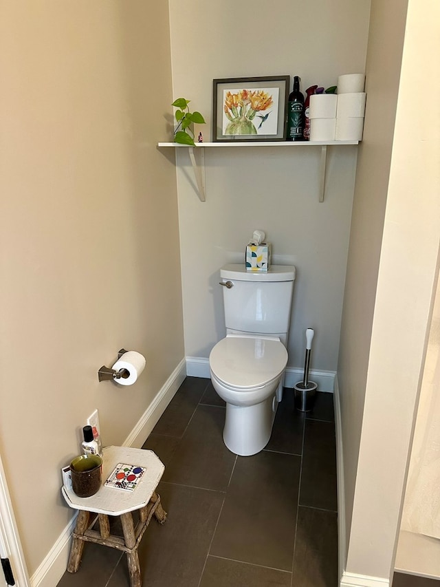bathroom featuring toilet, baseboards, and tile patterned flooring