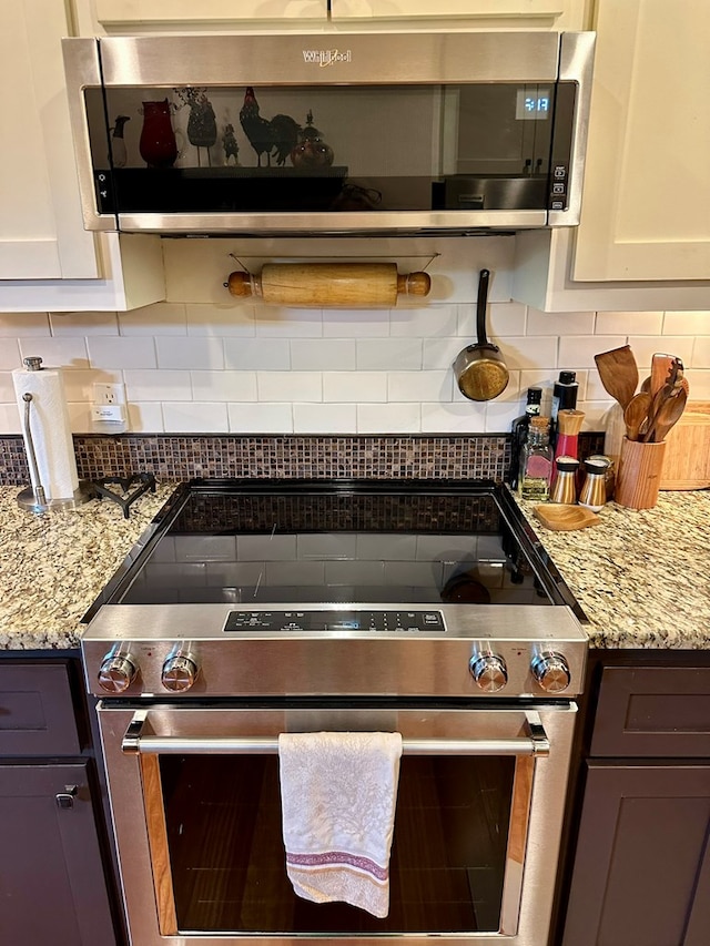 kitchen featuring appliances with stainless steel finishes, backsplash, and light stone counters