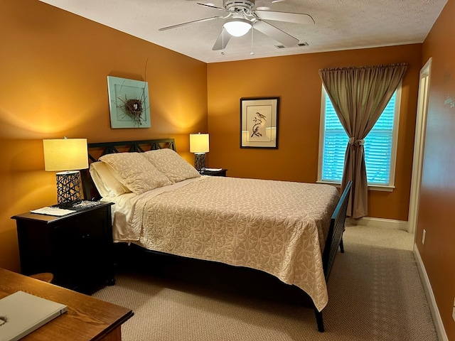 carpeted bedroom with a textured ceiling, baseboards, and ceiling fan