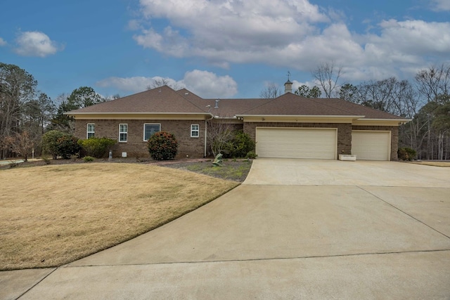 ranch-style home featuring a garage, brick siding, driveway, and a front yard