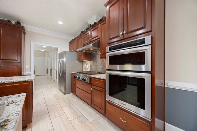 kitchen featuring decorative backsplash, light stone counters, ornamental molding, stainless steel appliances, and under cabinet range hood