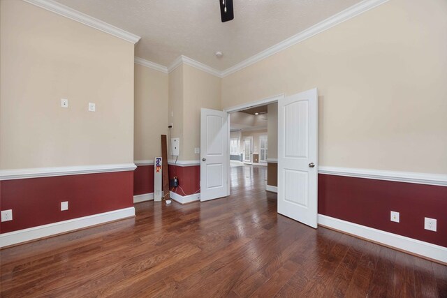 spare room with ornamental molding, baseboards, and wood finished floors