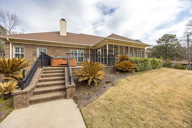 rear view of house with a sunroom, a chimney, stairway, a yard, and brick siding