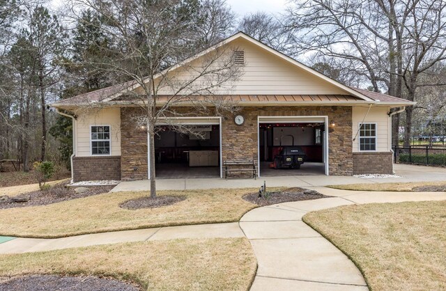 back of property featuring stone siding and fence