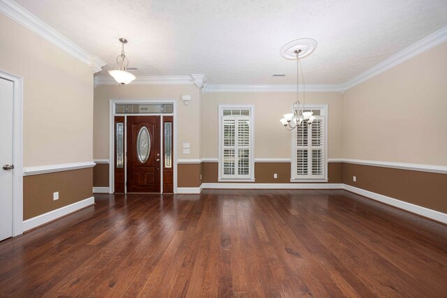 foyer entrance featuring crown molding, visible vents, baseboards, and wood finished floors