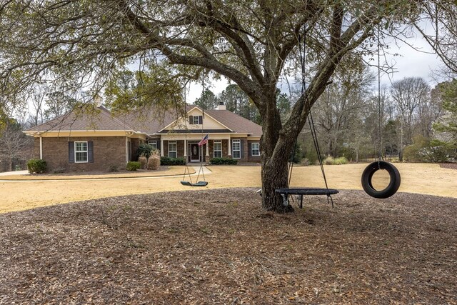 view of front of home with brick siding and a chimney