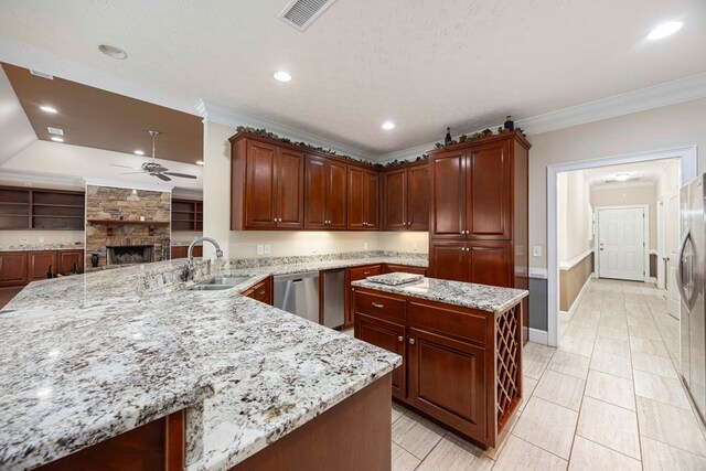 kitchen featuring visible vents, ceiling fan, light stone counters, ornamental molding, and a sink