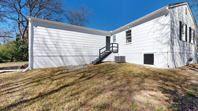 view of home's exterior with central air condition unit and a yard