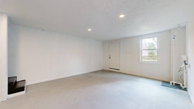 interior space with recessed lighting, a textured ceiling, concrete flooring, and baseboards