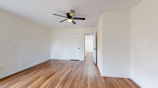 spare room with wood finished floors, baseboards, and ceiling fan